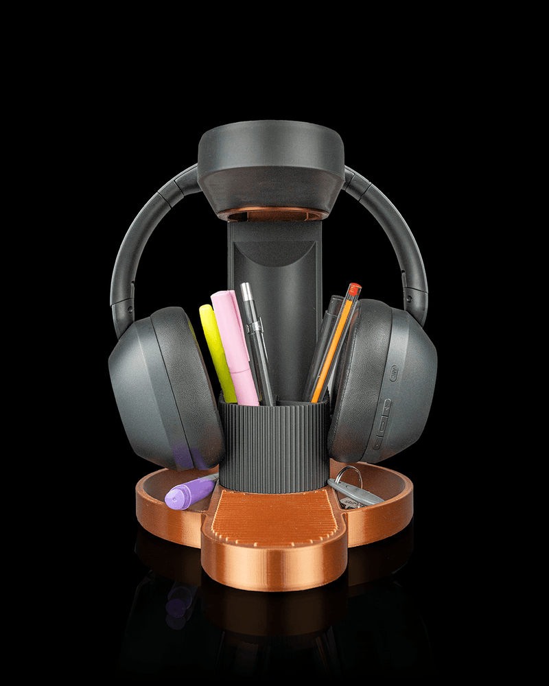 Tower Trio headphone stand with phone and pens on a copper base